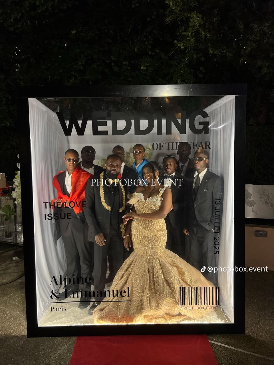 Bride and wedding party posing inside an illuminated magazine-cover booth