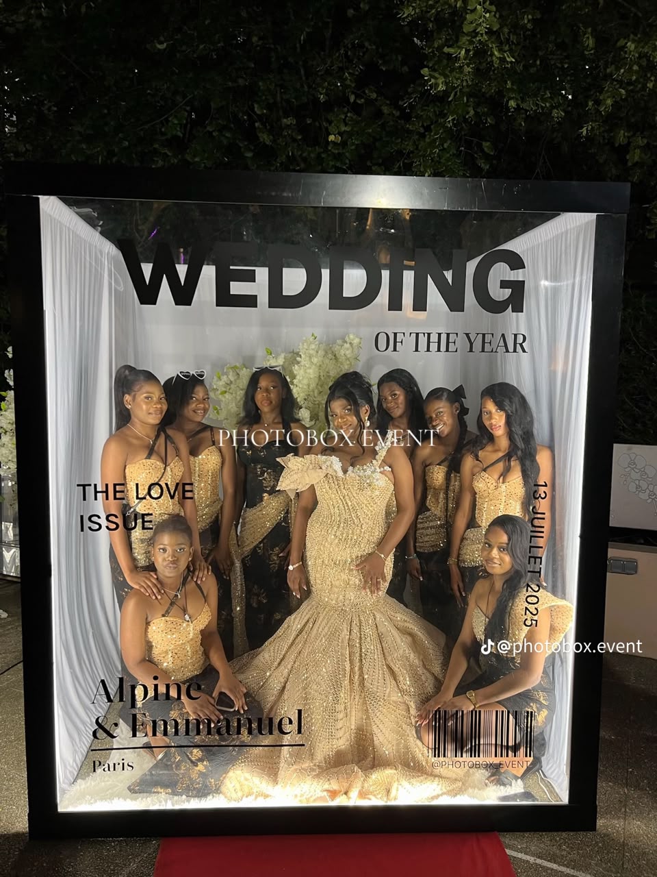 A bridal party posing together inside an illuminated magazine-cover booth
